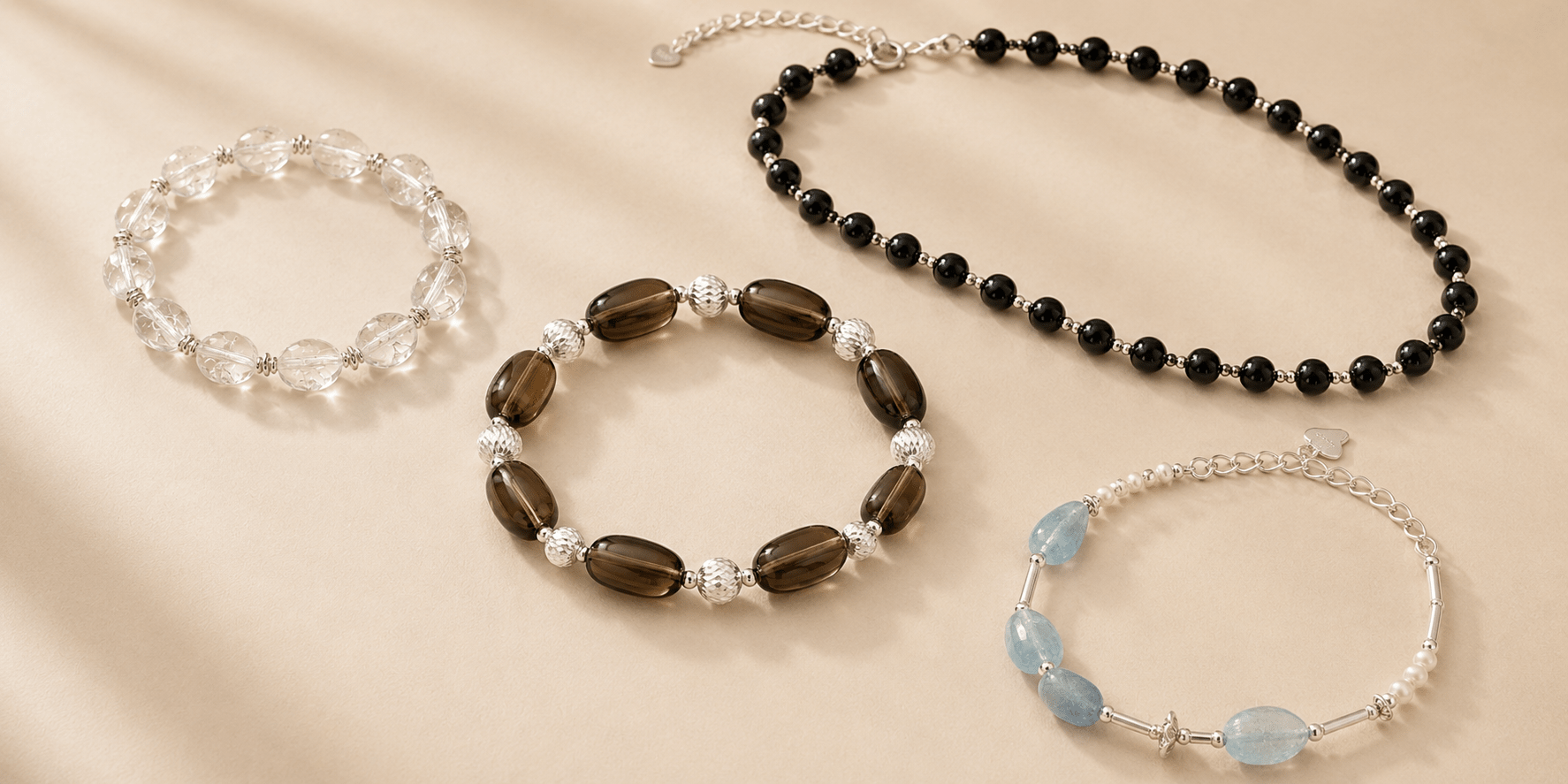LUNARAE natural stone jewelry featuring clear quartz, smoky quartz, black onyx, aquamarine and pearl on a warm beige background