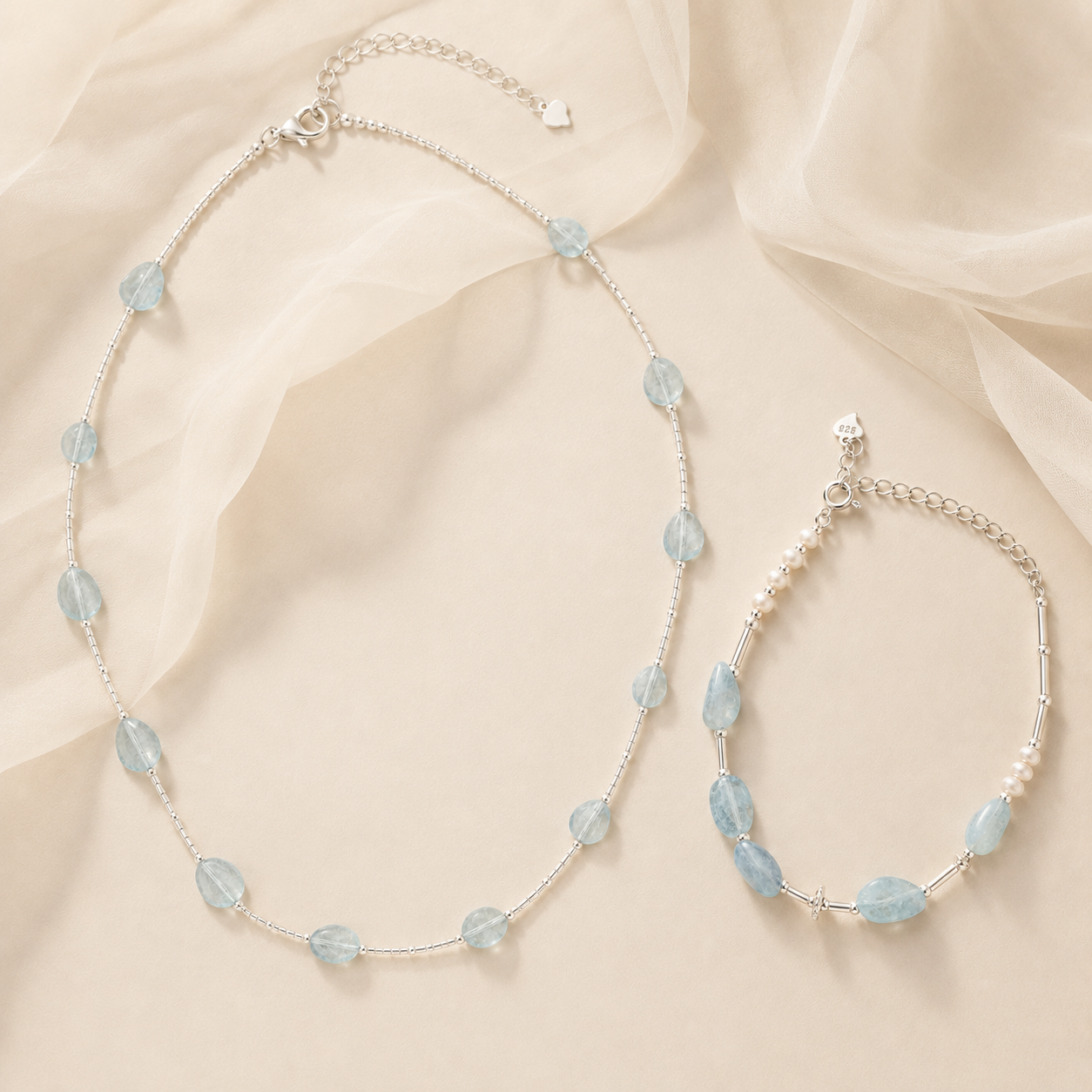 Aquamarine necklace and bracelet styled with soft ivory fabric for the LUNARAE Softness collection.