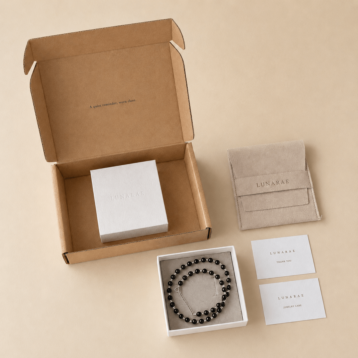 Black Onyx Bead Necklace presented with LUNARAE packaging including an open mailer box, jewelry box, pouch, thank you card, and jewelry care card
