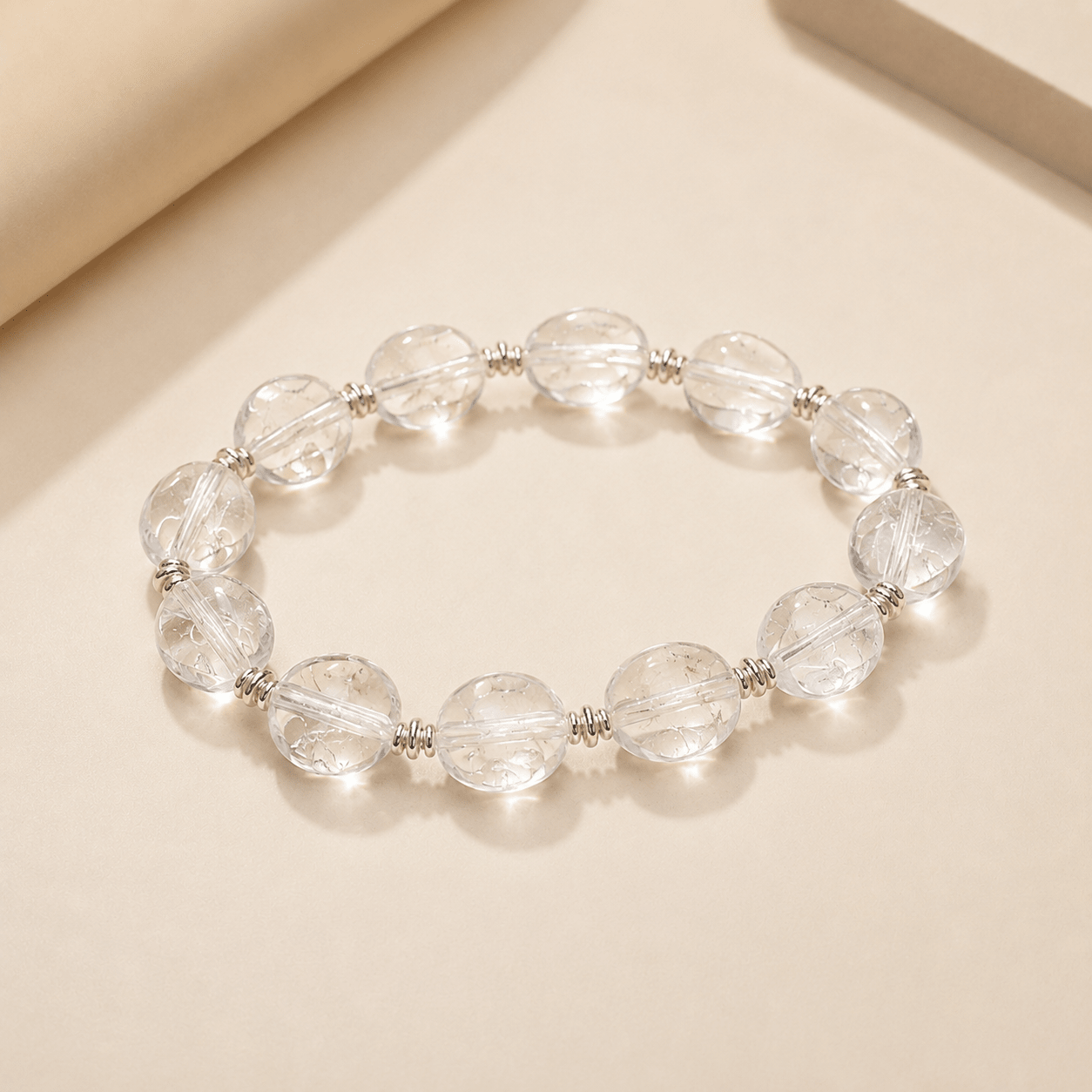 Clear Quartz Silver Bead Bracelet shown from an alternate flat-lay angle on a warm ivory background
