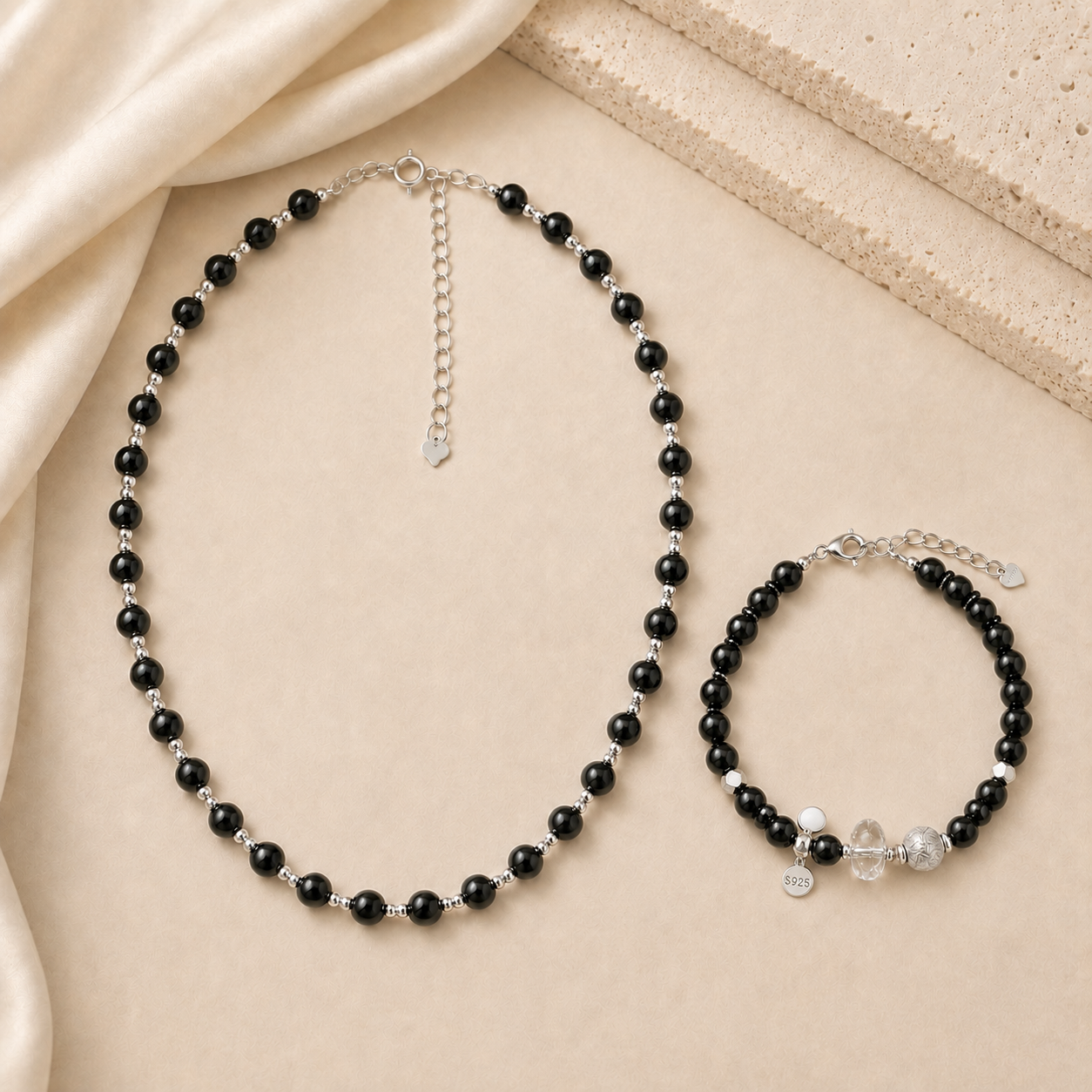 Black onyx bead necklace and black onyx bracelet styled with ivory satin and warm beige stone for the LUNARAE Protection collection.