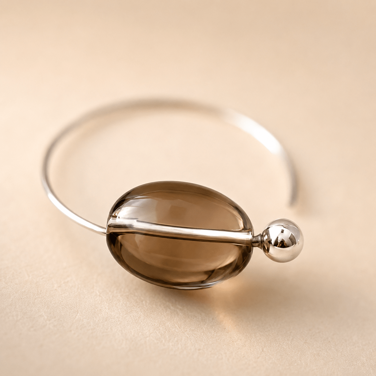 Close-up of a Smoky Quartz Hoop Earring showing the oval quartz bead, polished sterling silver bar, and round silver accent