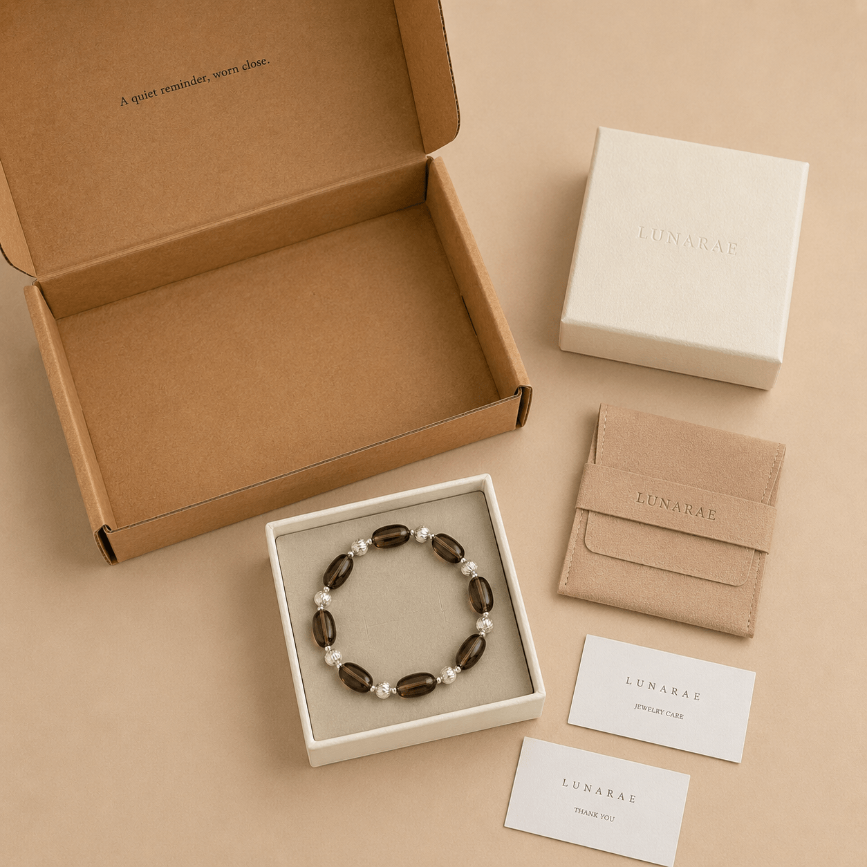 Smoky Quartz Stretch Bracelet presented with LUNARAE packaging including an open mailer box, jewelry box, pouch, thank you card, and jewelry care card