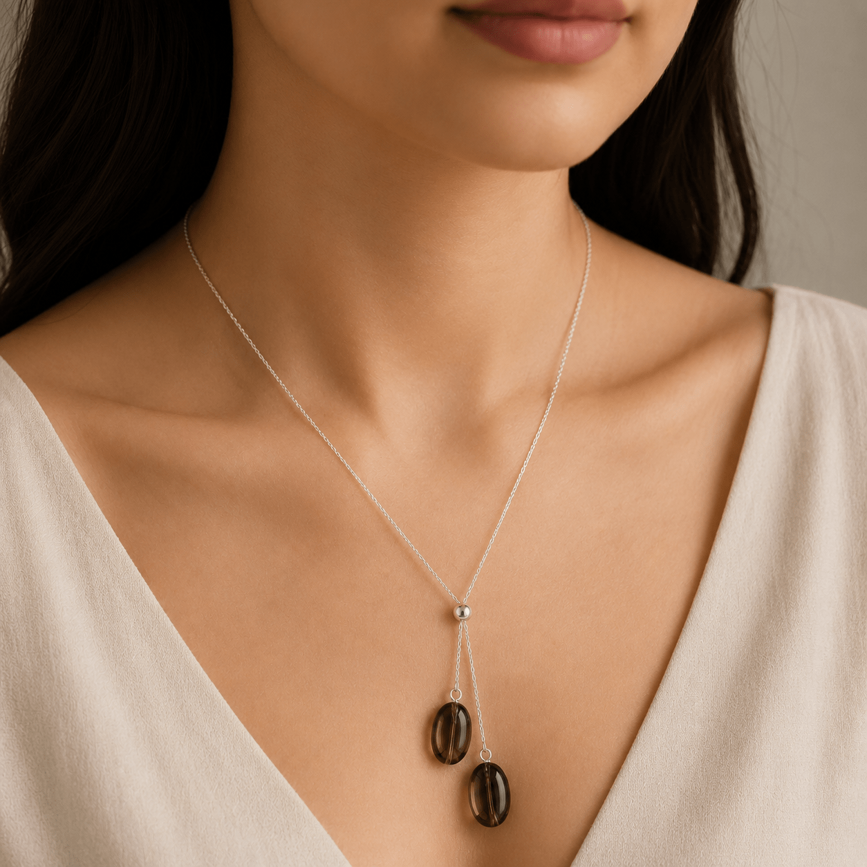 Smoky Quartz Y Necklace worn at the upper chest with two smoky quartz drops and a soft ivory V-neck top