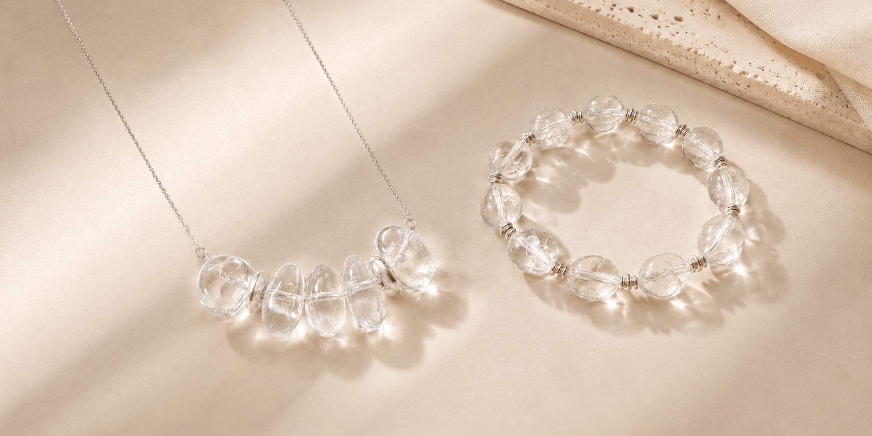 LUNARAE clear quartz necklace and bead bracelet on a warm beige background with soft natural light