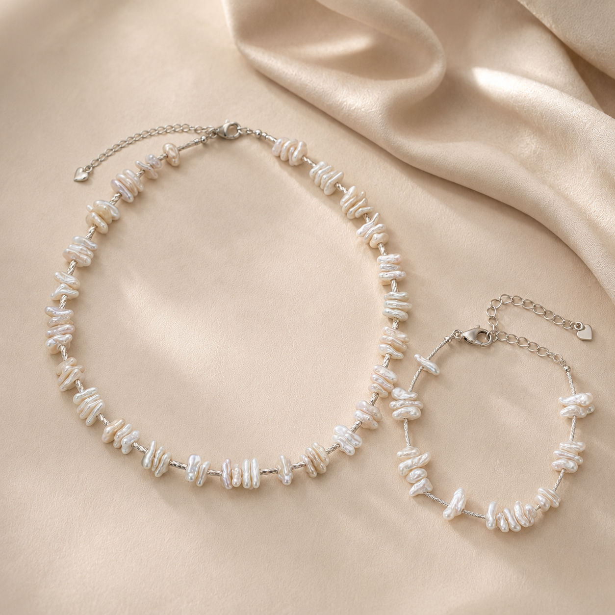 Baroque pearl necklace and bracelet arranged on soft ivory fabric for the LUNARAE Grace collection.