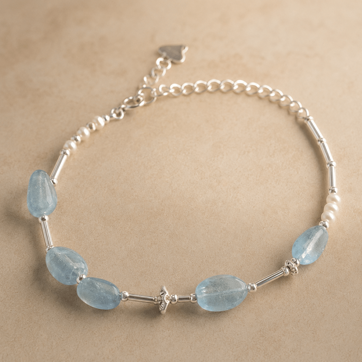 Aquamarine and Pearl Bracelet shown from an alternate flat-lay angle with the aquamarine stones, silver tube details, pearl accents, clasp, and extender chain visible