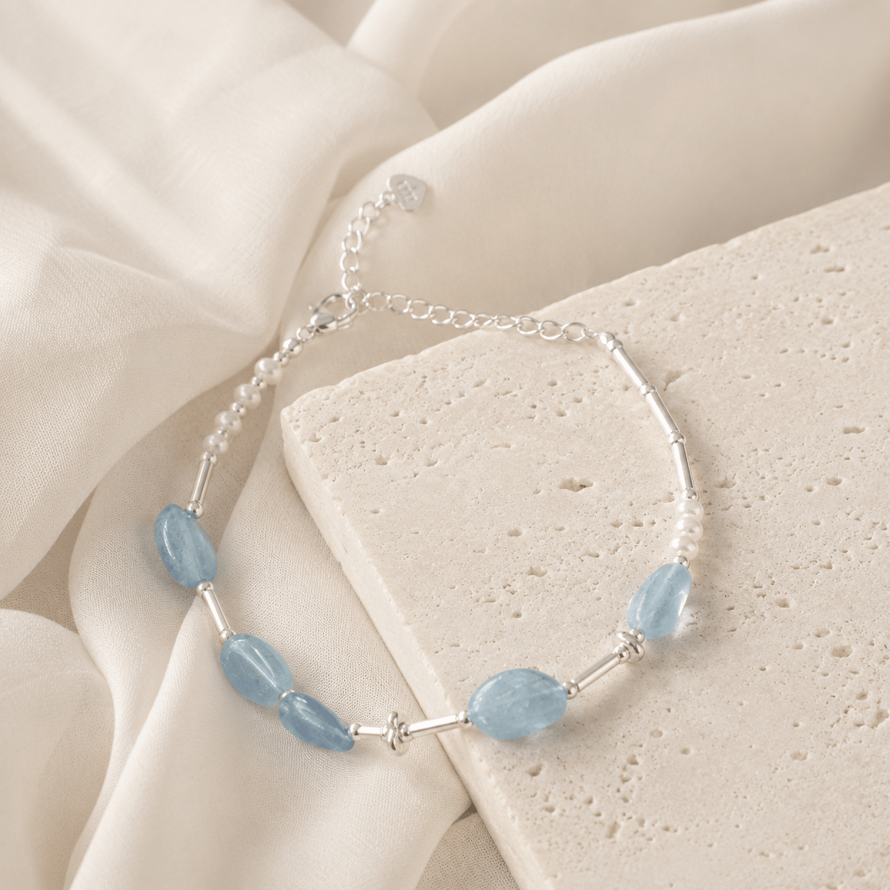 Close-up of the Aquamarine and Pearl Bracelet showing translucent pale blue aquamarine stones, freshwater pearls, sterling silver tubes, and decorative silver rings