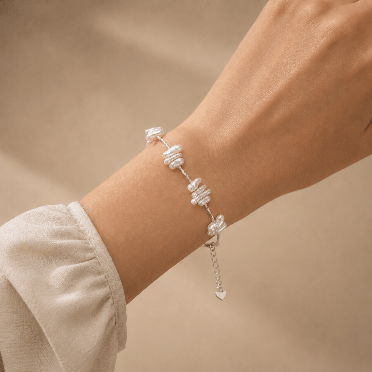 Baroque Pearl Bracelet worn on the wrist with softly draped ivory clothing