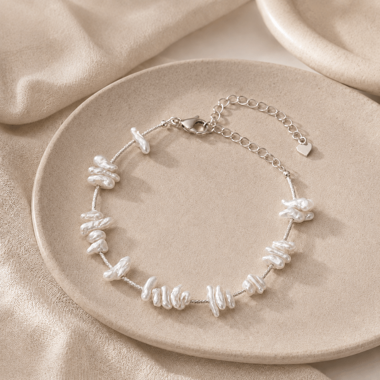 Baroque Pearl Bracelet styled on a ceramic plate with softly draped neutral fabric