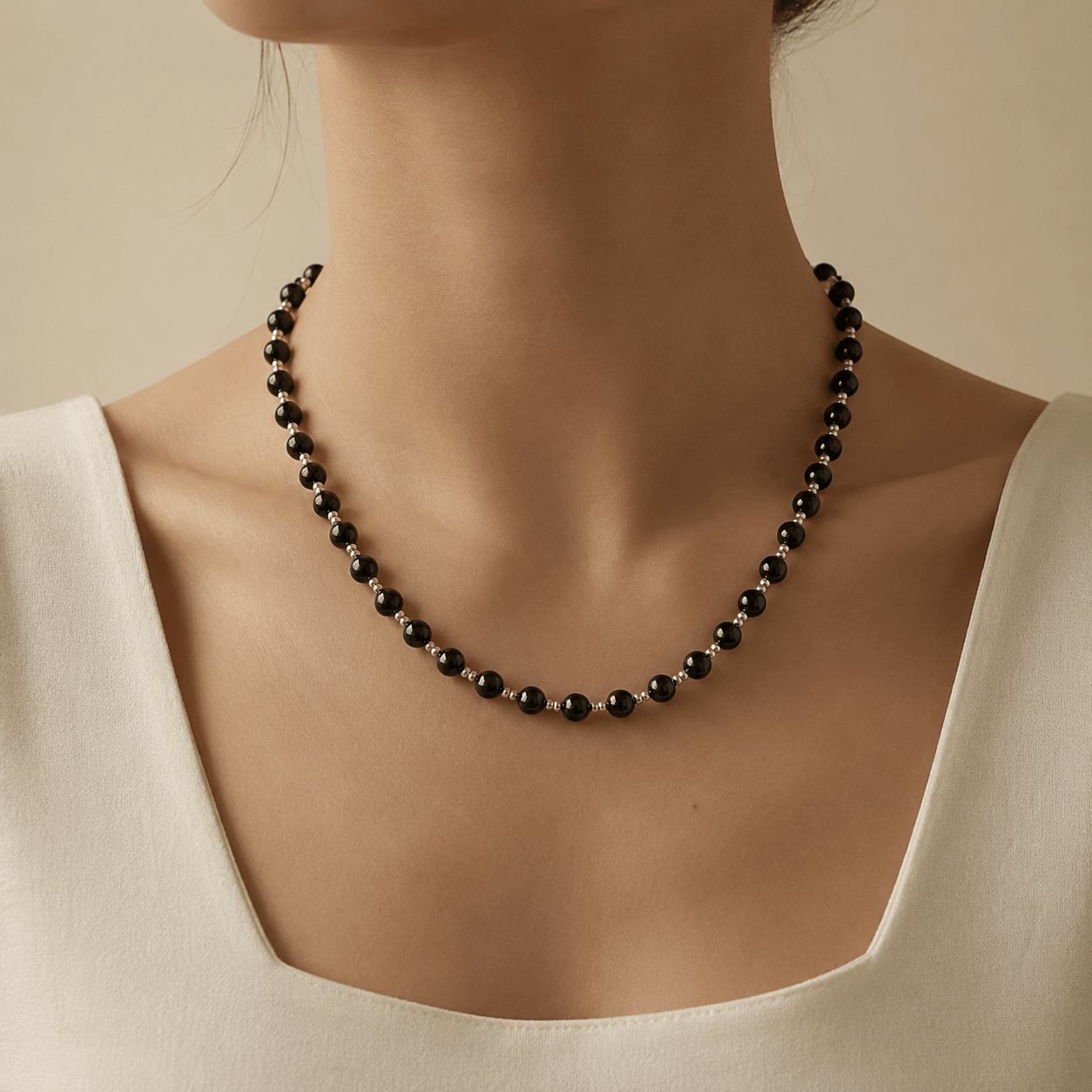 Black Onyx Bead Necklace worn at the upper chest with a soft ivory square-neck top