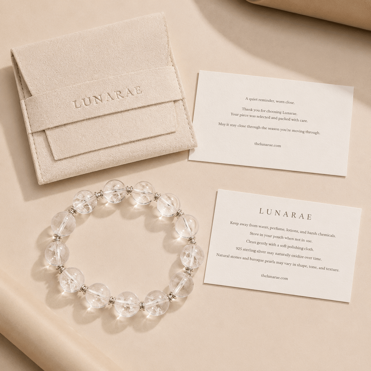 Clear Quartz Silver Bead Bracelet displayed with a LUNARAE pouch, thank you card, and jewelry care card in a warm neutral flat lay