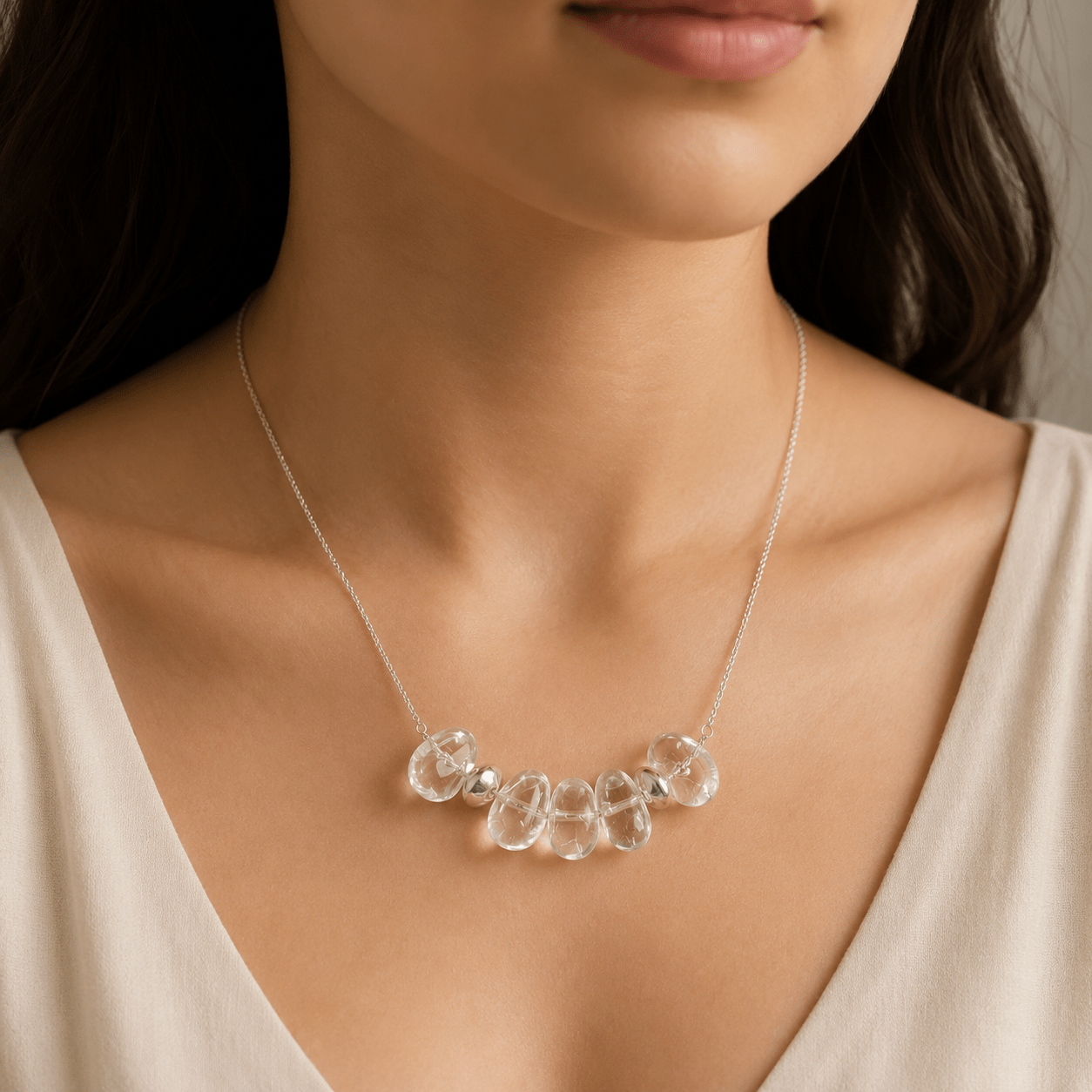Clear Quartz Pendant Necklace worn on the upper chest with a soft ivory top