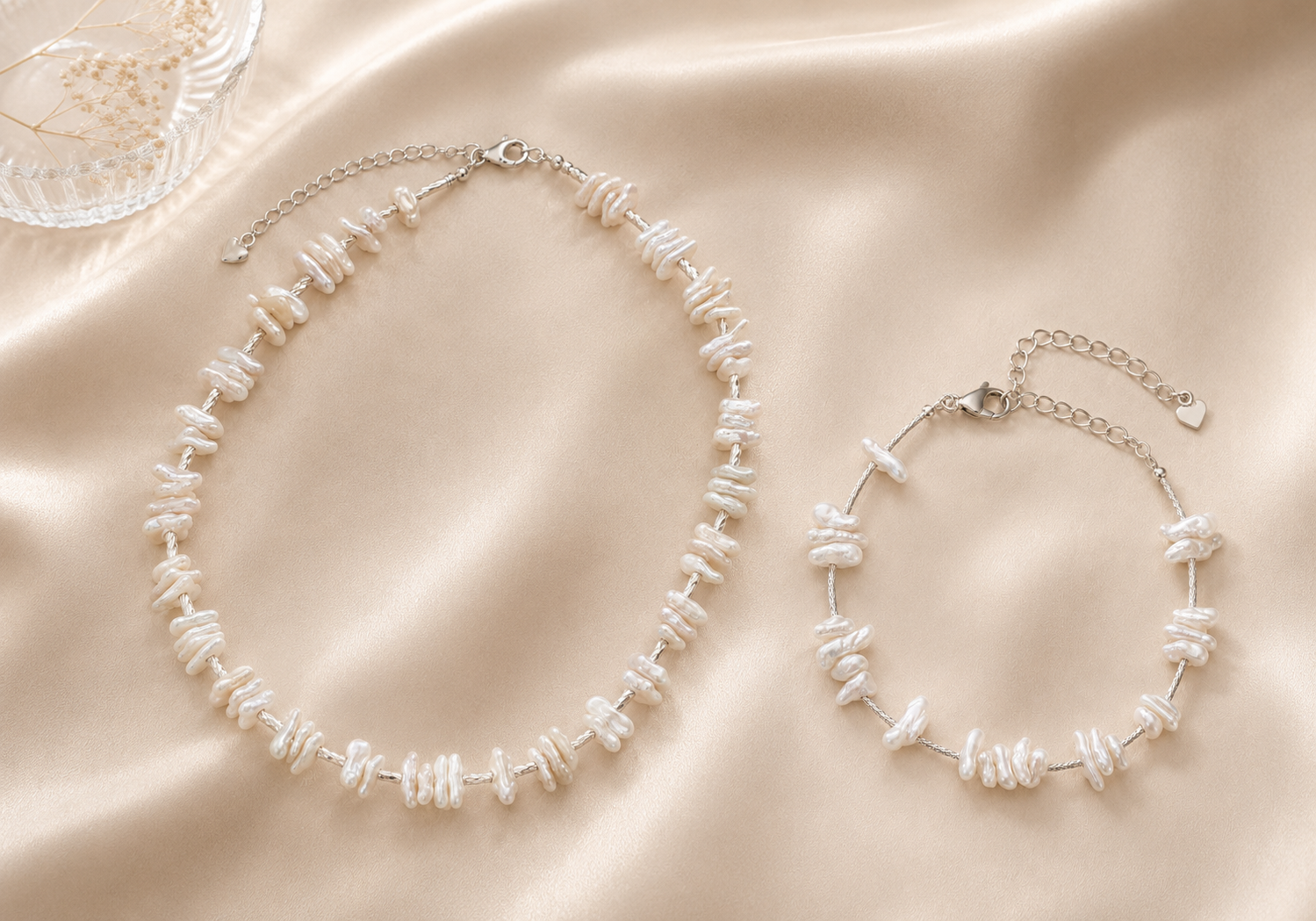 Baroque pearl necklace and bracelet arranged on warm ivory silk