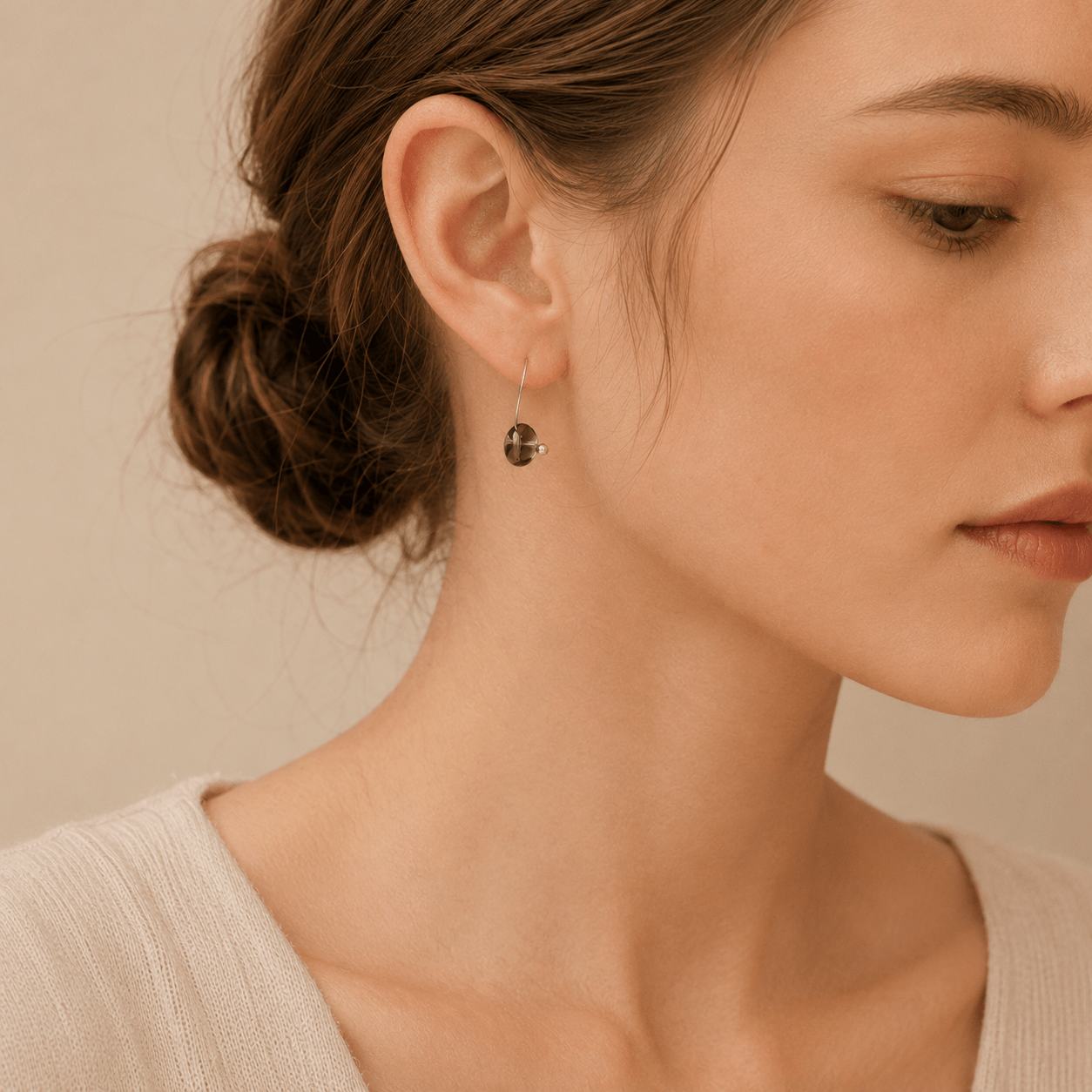 Woman wearing a Smoky Quartz Hoop Earring with a polished sterling silver hoop and oval brown quartz bead
