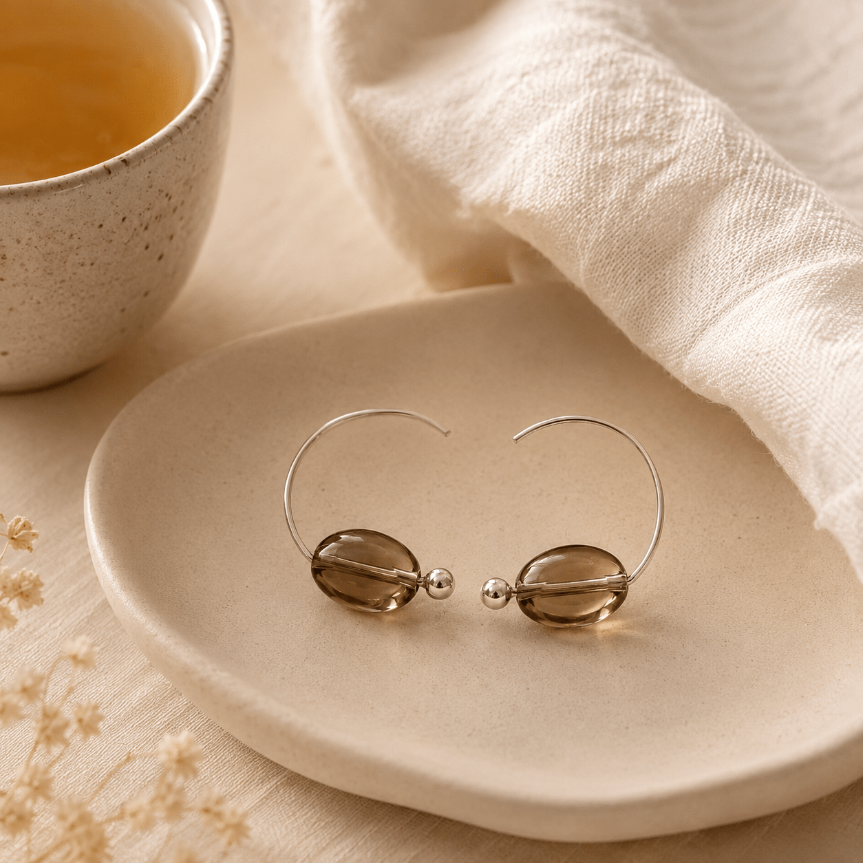Smoky Quartz Hoop Earrings styled on a neutral ceramic tray beside soft fabric and a ceramic cup