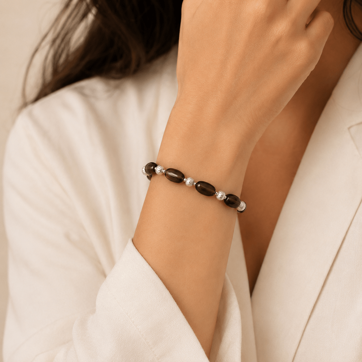 Smoky Quartz Stretch Bracelet worn on the wrist with a soft ivory blazer