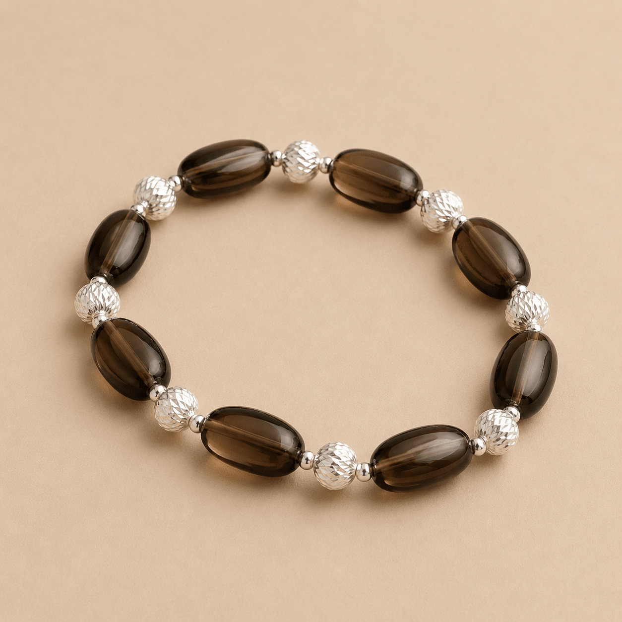 Smoky Quartz Stretch Bracelet shown from an alternate flat-lay angle with alternating oval quartz stones and textured silver beads
