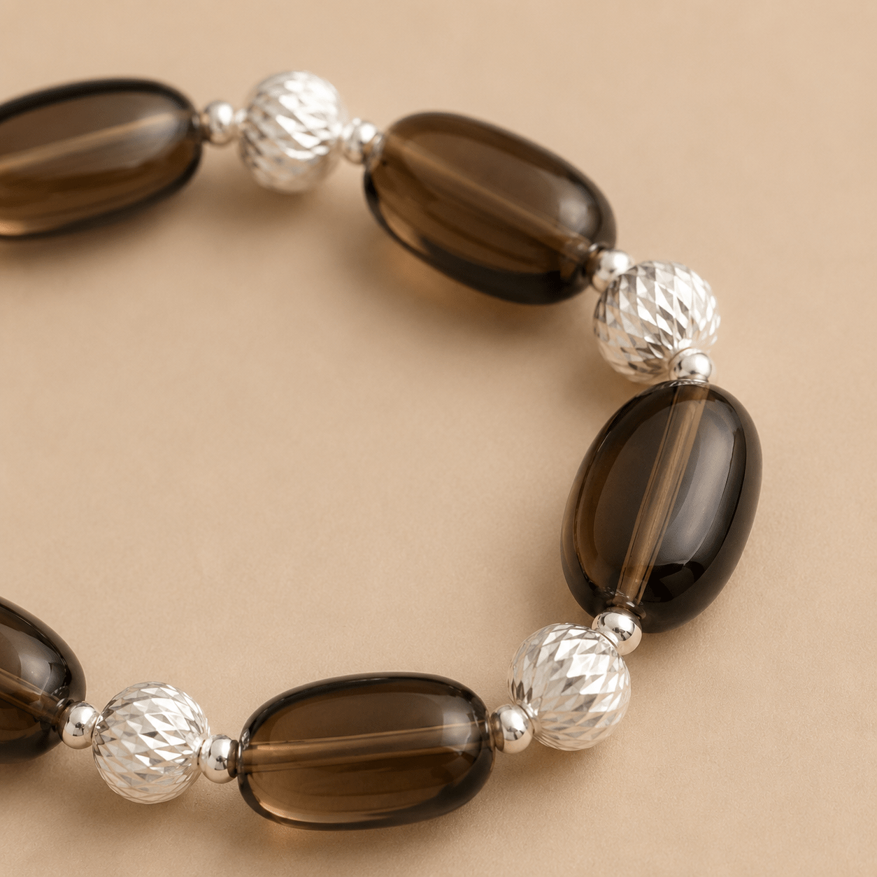 Close-up of the Smoky Quartz Stretch Bracelet showing translucent brown quartz stones, faceted sterling silver beads, and polished silver spacers