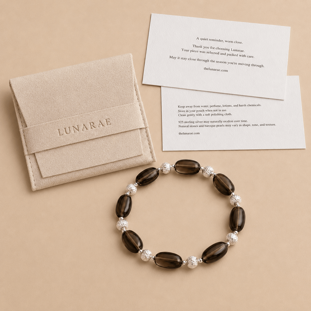 Smoky Quartz Stretch Bracelet displayed beside a LUNARAE pouch, thank you card, and jewelry care card with care instructions for natural stones and sterling silver